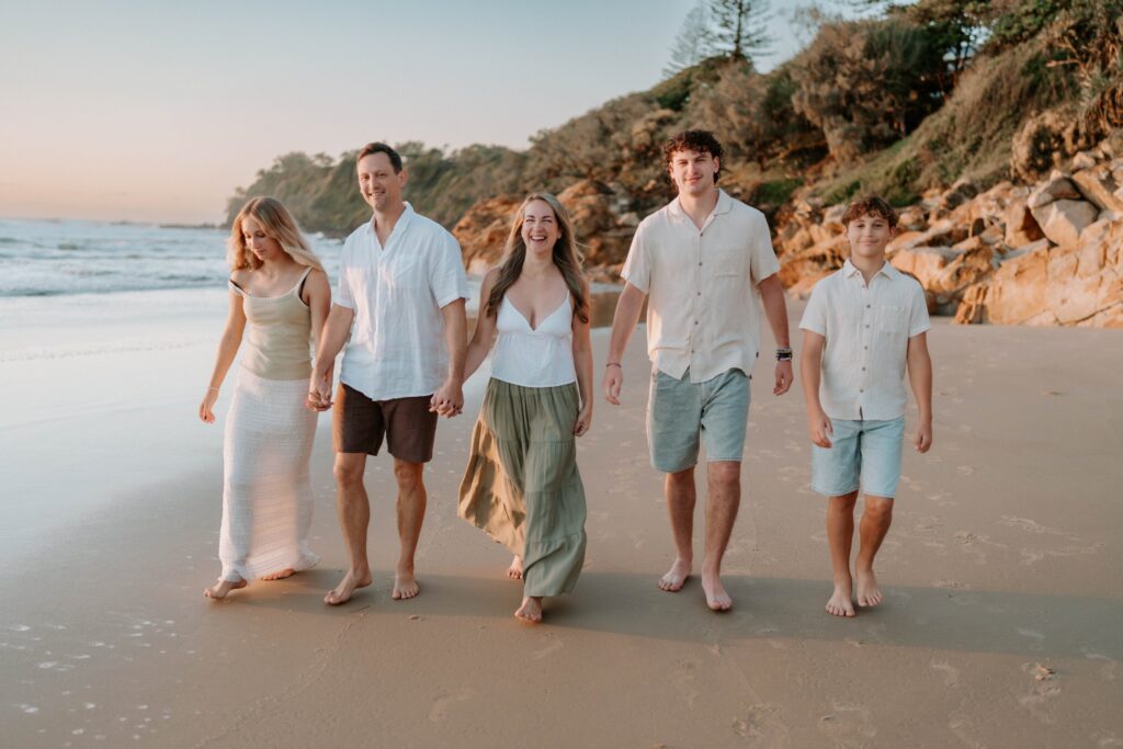 Family walking on a Sunshine Coast beach at golden hour
